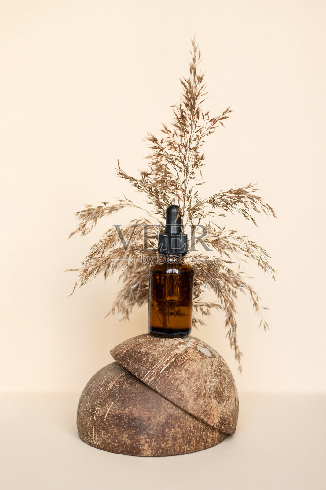 棕色瓶子与化妆品在自然米色的背景与椰子壳和干树枝。照片摄影图片