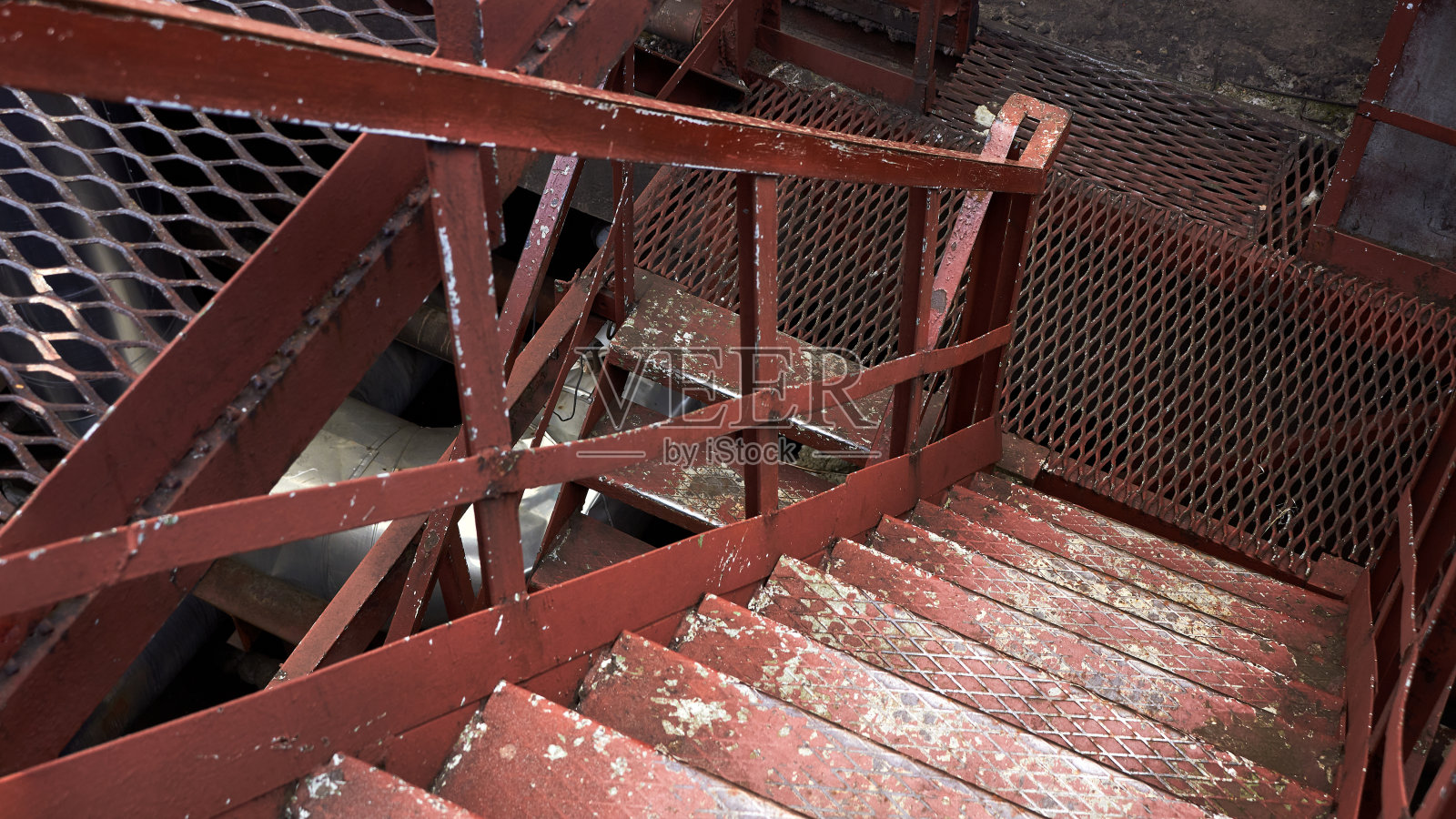 化工厂蒸汽朋克复古风格的室内部分与copyspace的例子。抽象图像工业纹理锈棕色楼梯垂直向下或楼下的钢金属板16x9。照片摄影图片