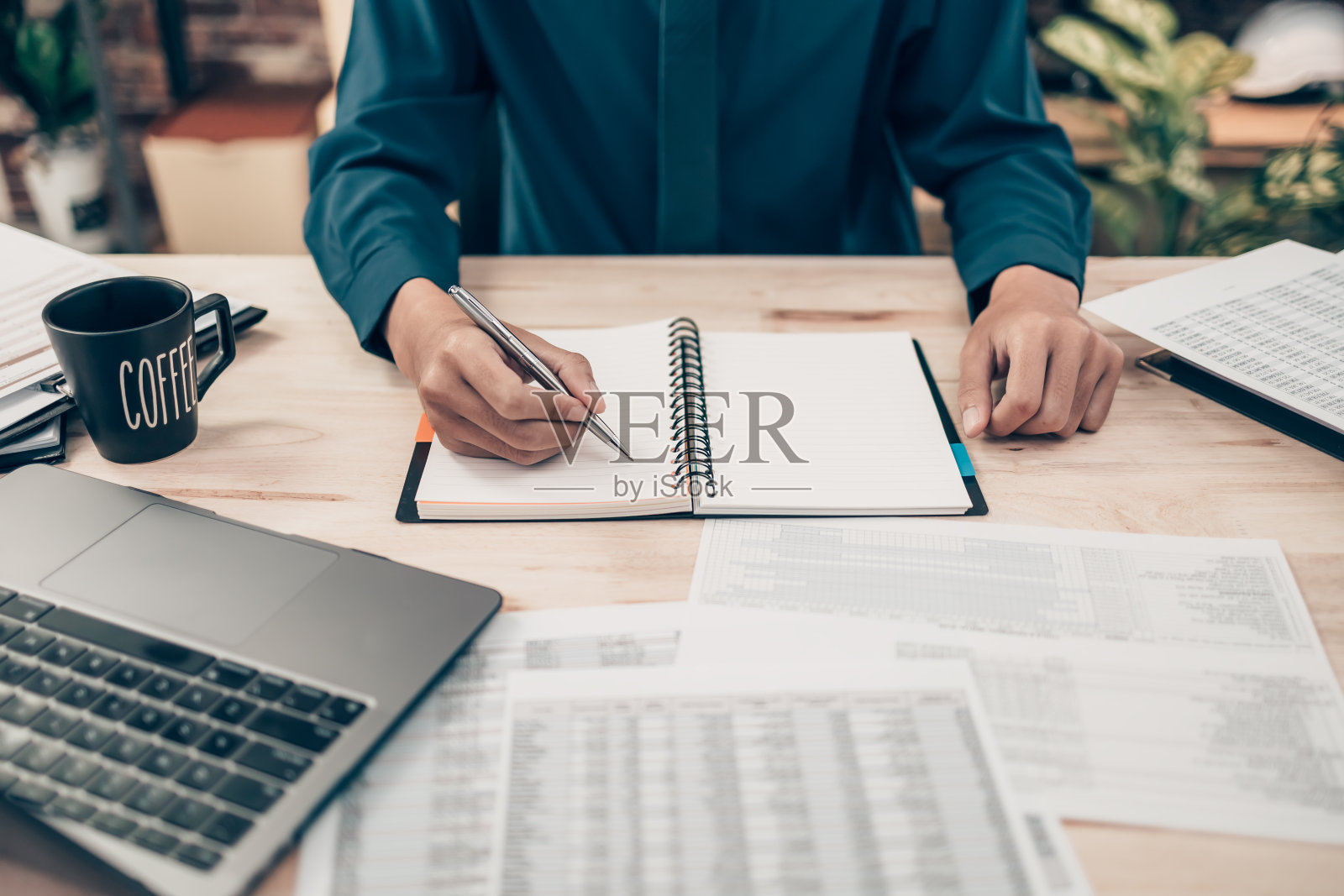 投资者在办公桌办公室工作，使用平底锅和指向检查跟踪成本，余额，利润和货币。会计与财务概念。照片摄影图片