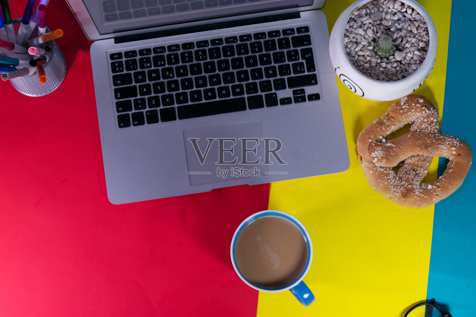 办公室办公桌工作空间-平板俯视图工作空间与笔记本电脑，智能手机，咖啡和笔记本在蓝色粉彩背景上的模型照片。粉彩蓝色背景工作桌的概念照片摄影图片