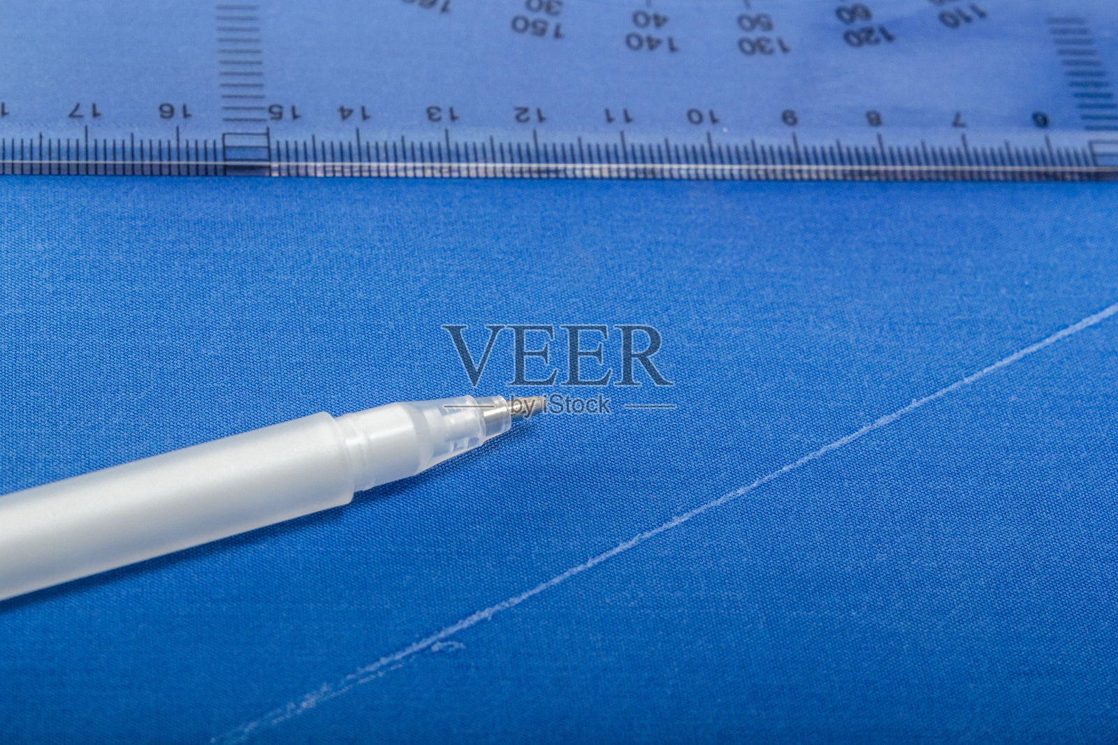 蓝色布料上有白色的马克笔和图案照片摄影图片