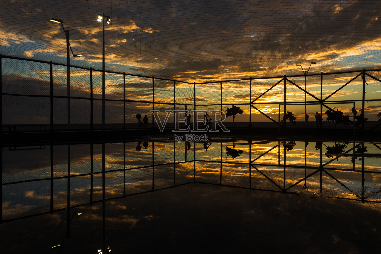 体育球场剪影对戏剧性的橙色日落。照片摄影图片