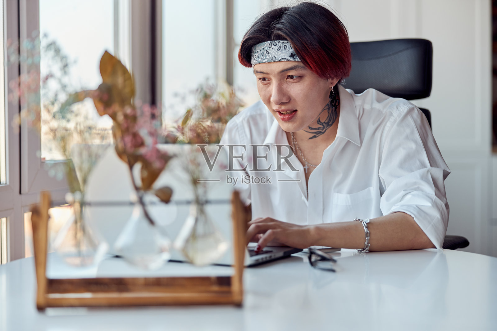 一名亚洲男子坐在家里用笔记本电脑打字照片摄影图片