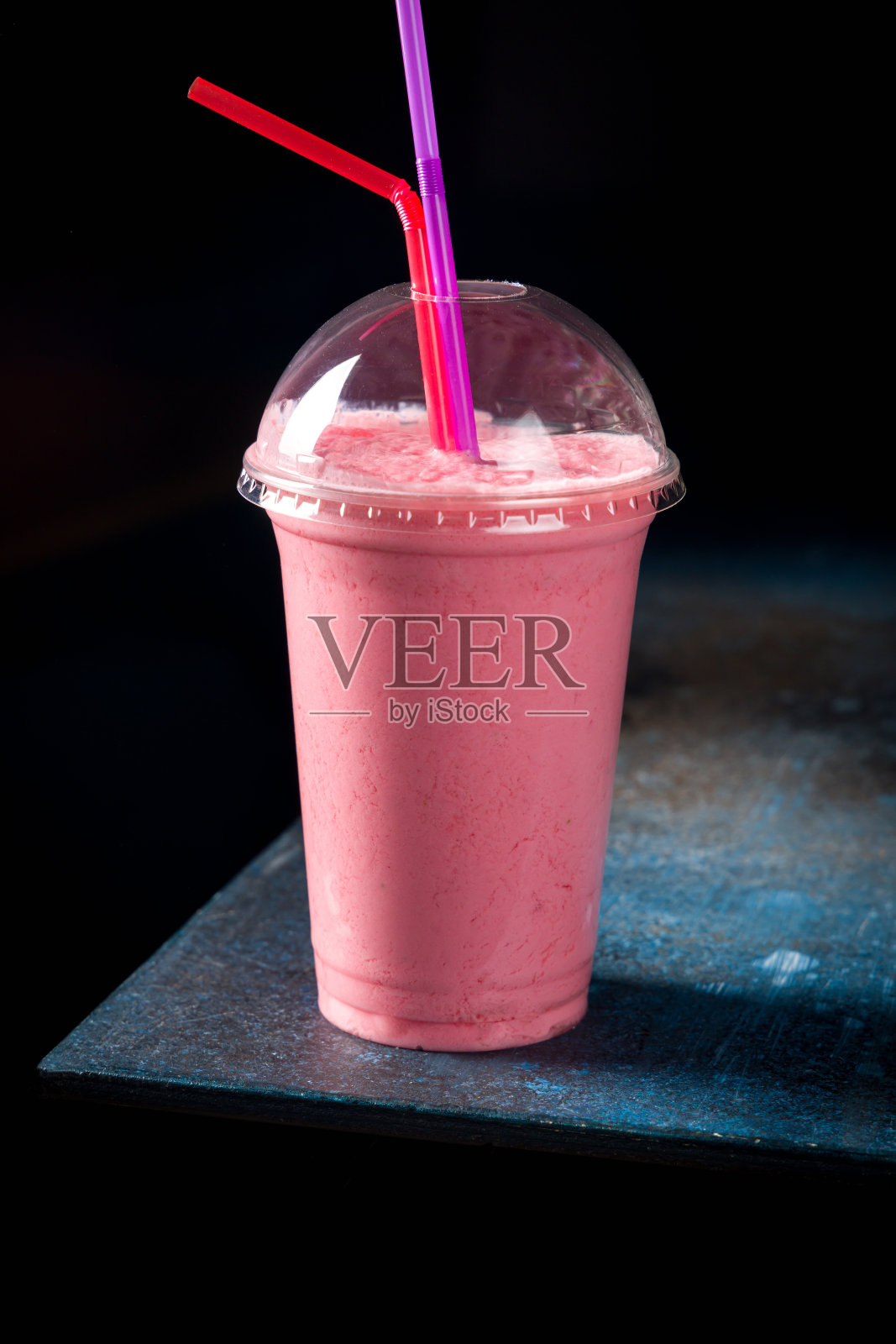 草莓奶昔在深风格在深蓝色的桌子上照片摄影图片