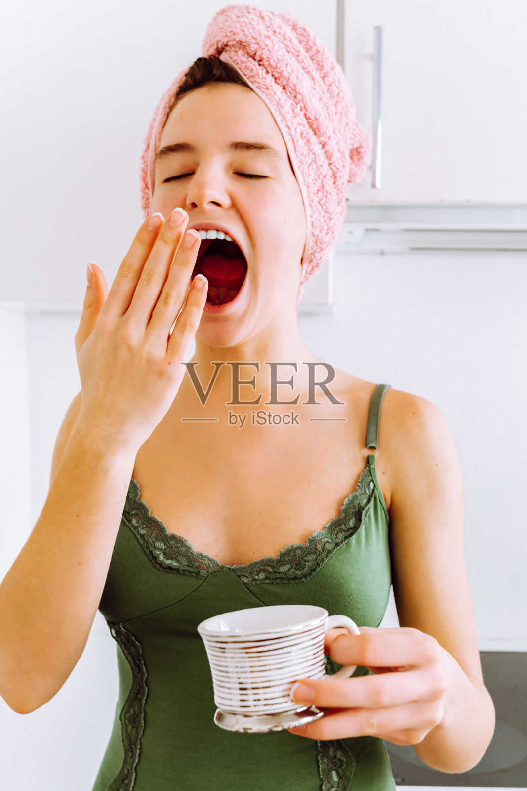 清晨用手捂着哈欠照片摄影图片