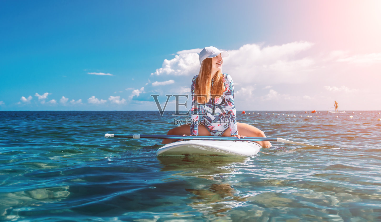 比基尼健康快乐女子在SUP冲浪板上放松，漂浮在清澈的碧绿海水中，休闲运动，桨板运动，夏季乐趣，度假旅行，积极的生活方式照片摄影图片
