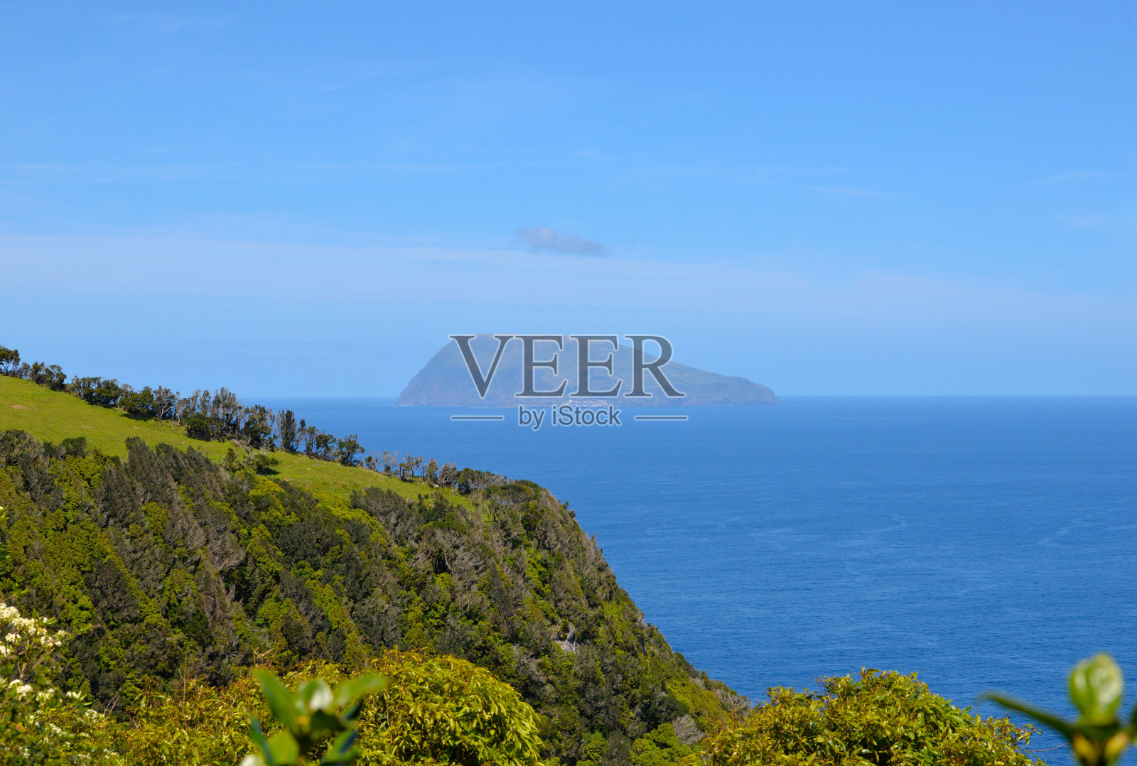 亚速尔群岛-弗洛雷斯海岸线和科沃岛在地平线上照片摄影图片