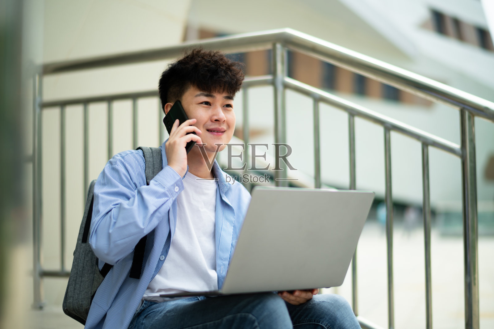 亚洲年轻帅哥在地铁站使用笔记本电脑照片摄影图片