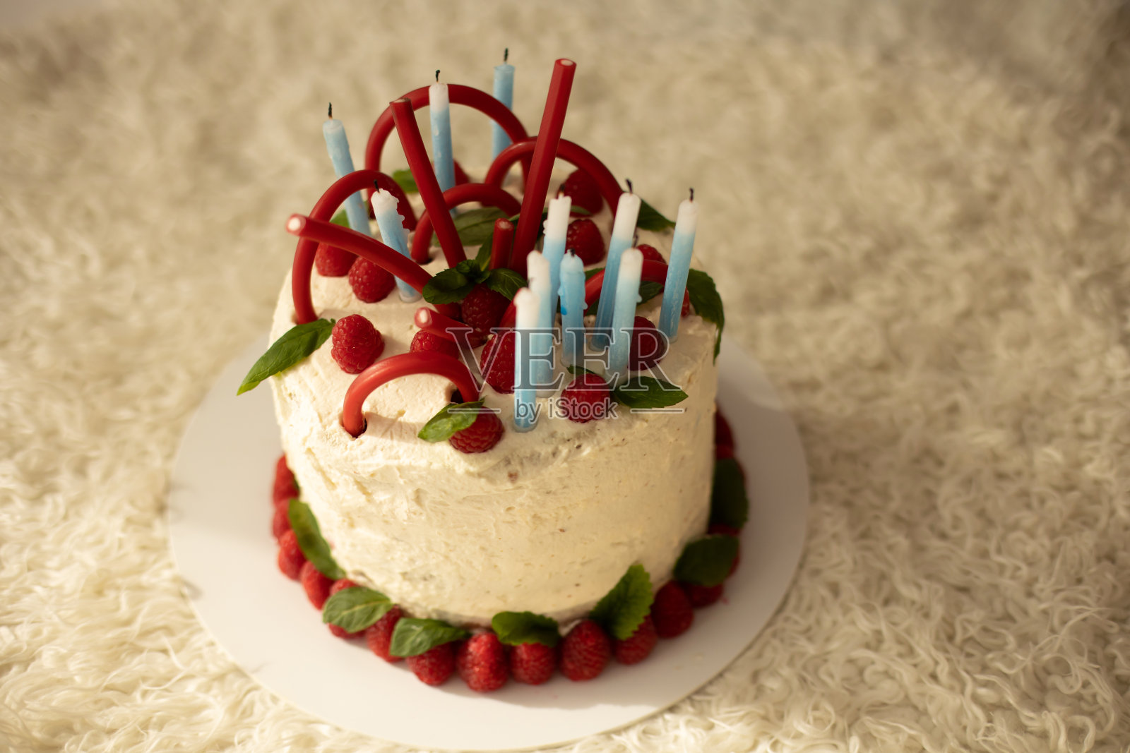 可爱的孩子，学龄前的男孩，在家里用自制的覆盆子蛋糕，薄荷和糖果庆祝生日照片摄影图片