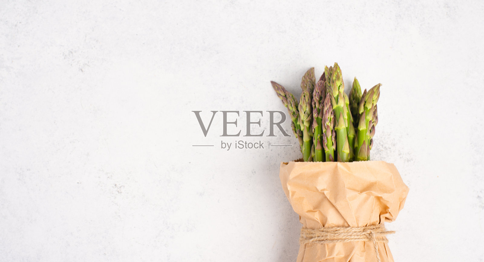 新鲜绿色的芦笋束在白色纹理的桌子上，蔬菜在春天，美食美食，烹饪一顿素食照片摄影图片