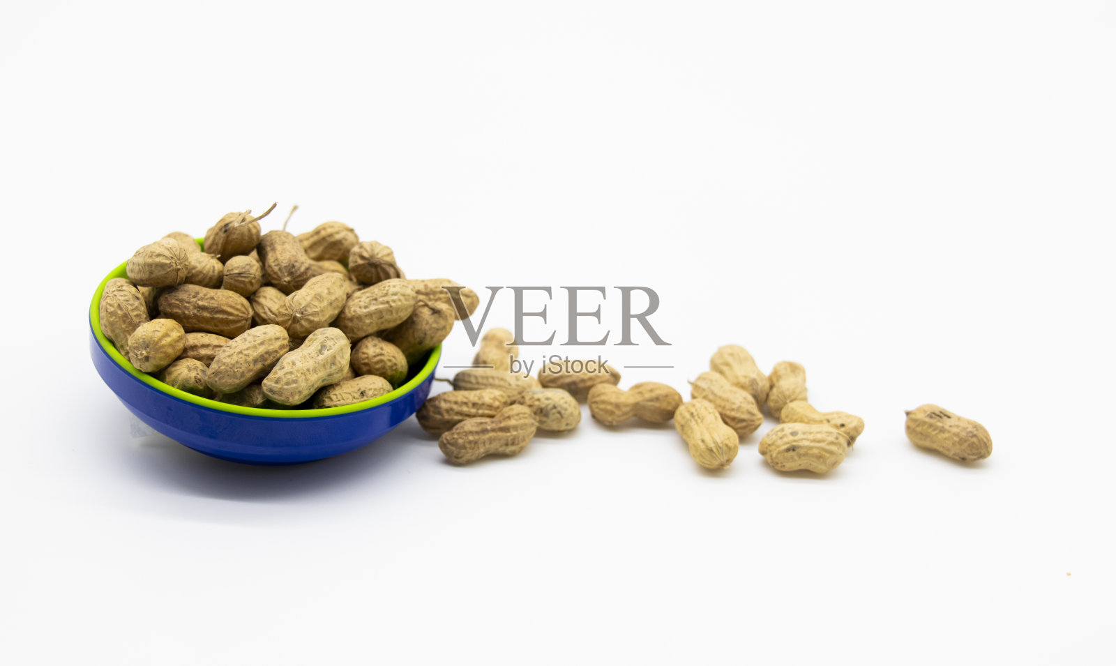 把未剥皮的花生放在一个杯子里，放在白色背景上照片摄影图片