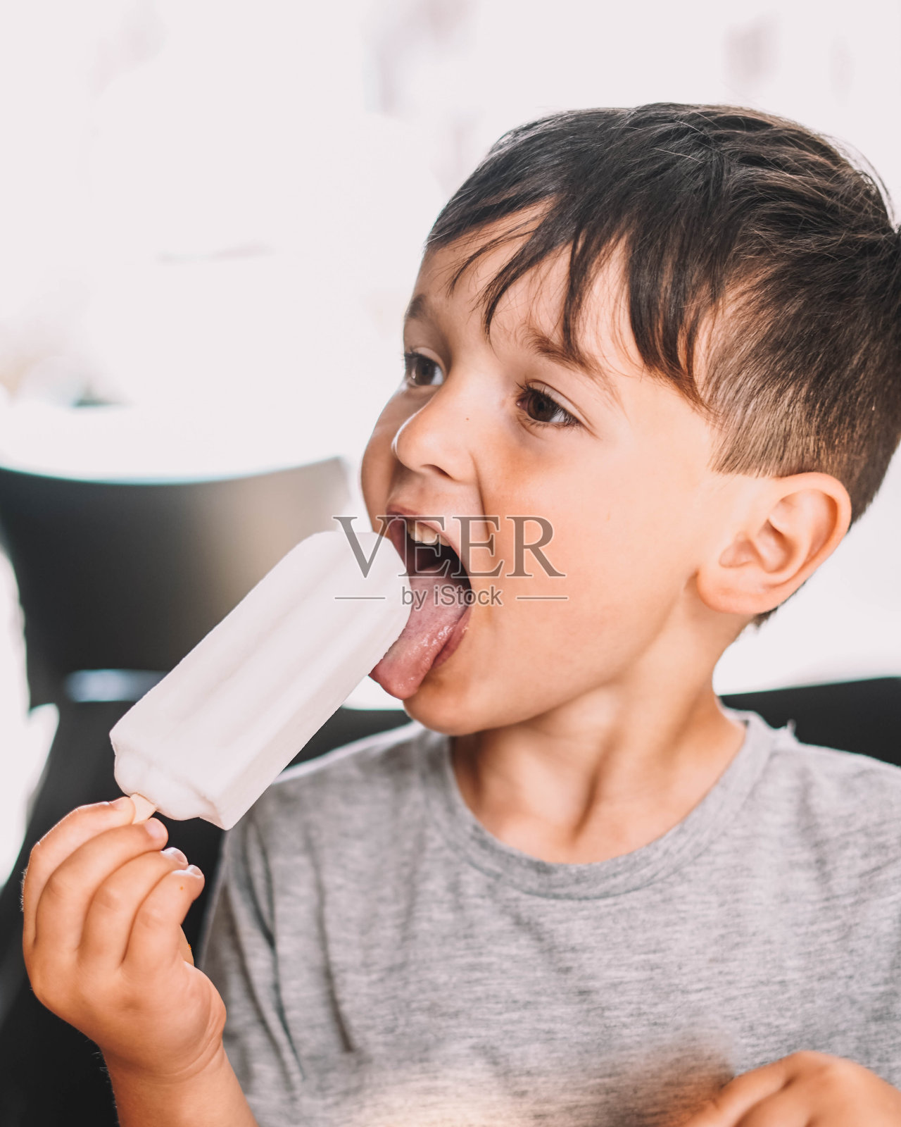 男孩在享受椰子冰淇淋照片摄影图片