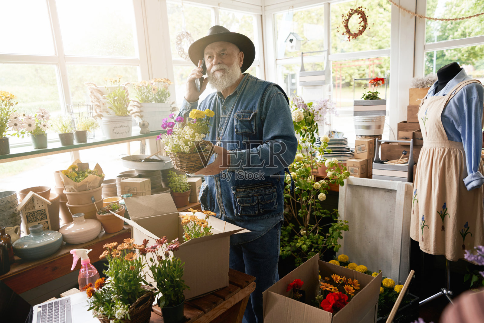 微笑的老花匠在工作时打电话照片摄影图片