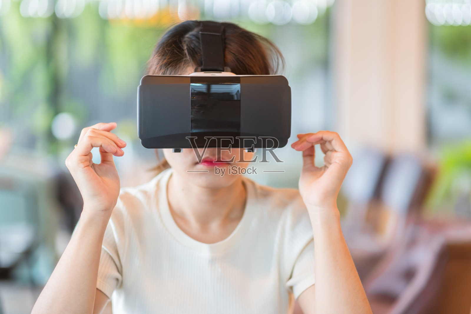 年轻女子使用虚拟现实头盔。VR，未来数字技术，游戏，娱乐，元宇宙，NFT和3D网络空间概念照片摄影图片