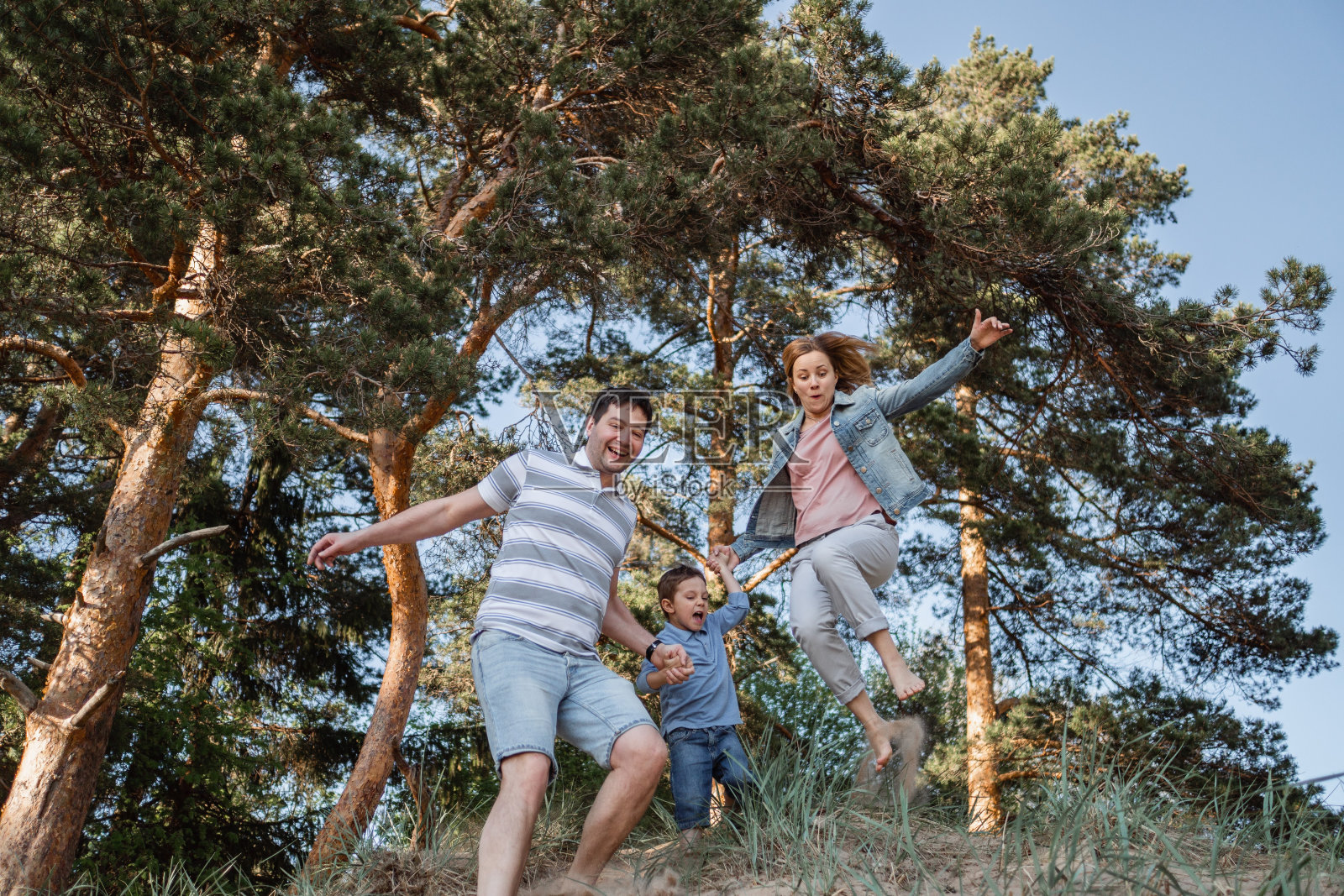 快乐的一家人在夏日的沙滩上奔跑照片摄影图片