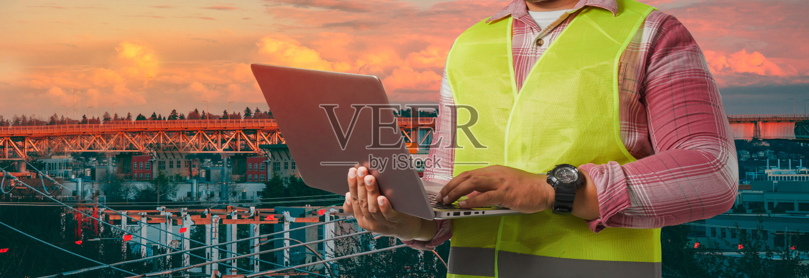 全景首席工程师戴着一只会反光的老虎，手里拿着一台笔记本电脑。孤立在城市背景剪接路径。副本的空间。照片摄影图片