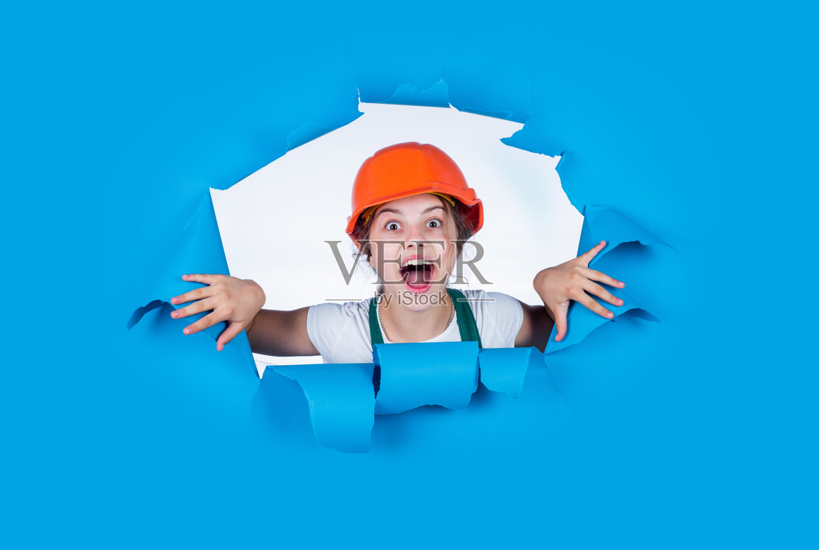 我想我能修好它。孩子们在工地上戴头盔。十几岁的女孩建筑工人的制服。孩子在修理工作。车间改造理念。繁忙的专业木匠照片摄影图片