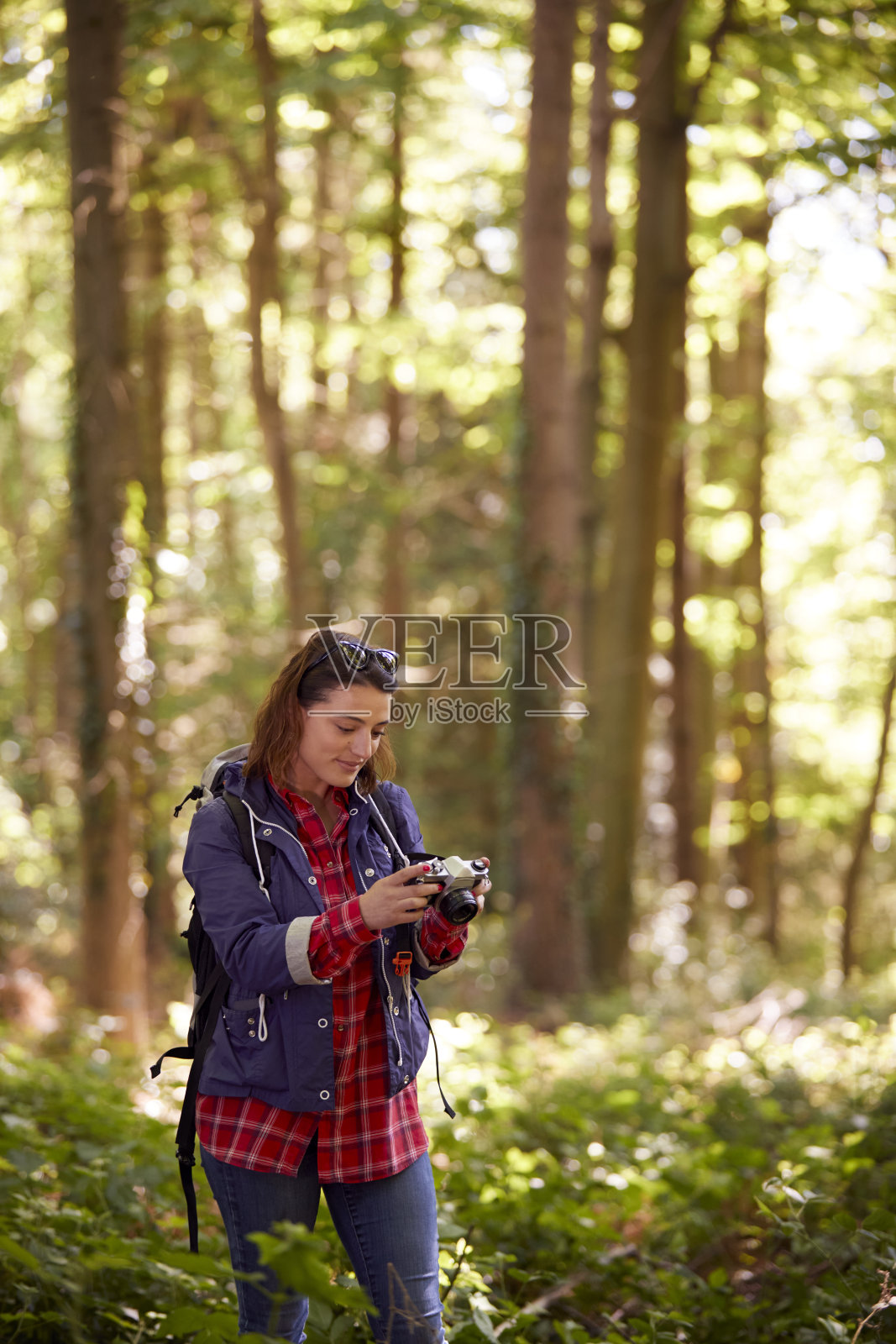 徒步穿越森林的女子用单反相机拍照照片摄影图片