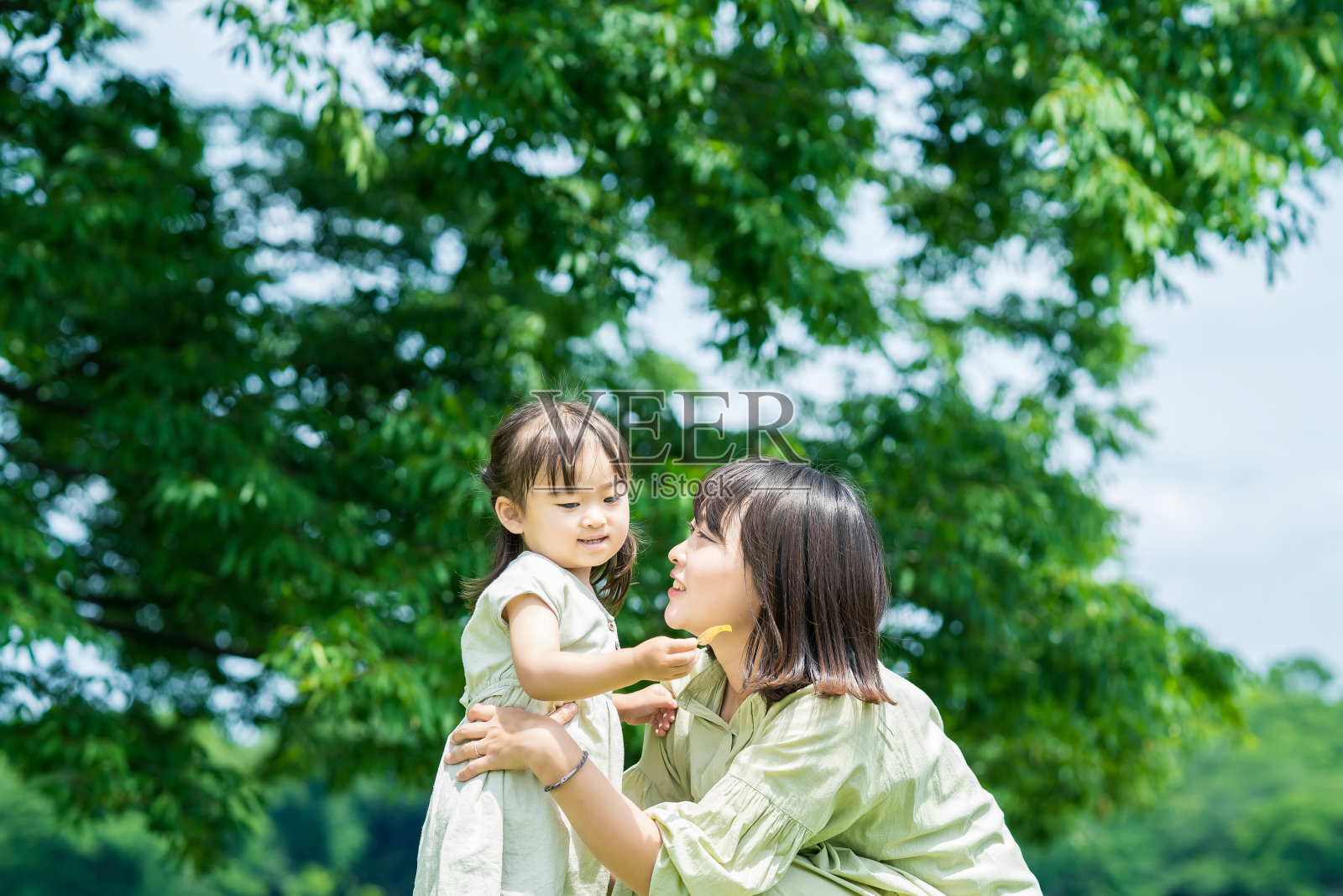 母亲和女儿在公园里拥抱照片摄影图片
