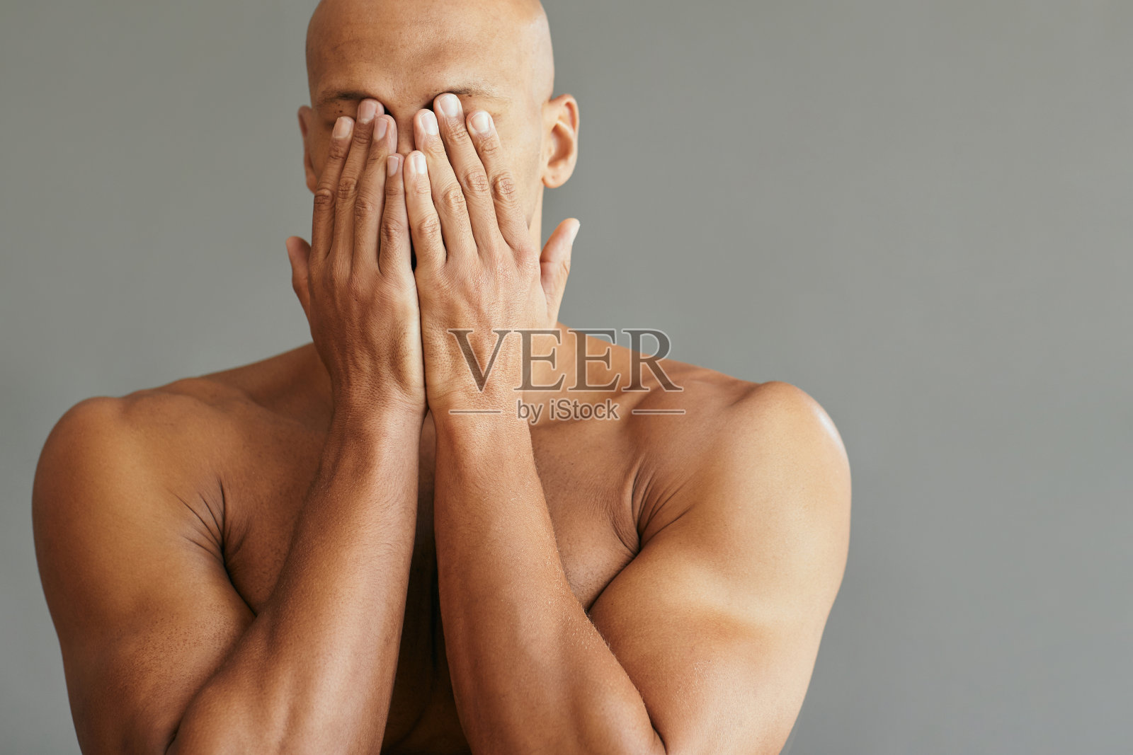 一个面目模糊的黑人用手捂着脸。照片摄影图片