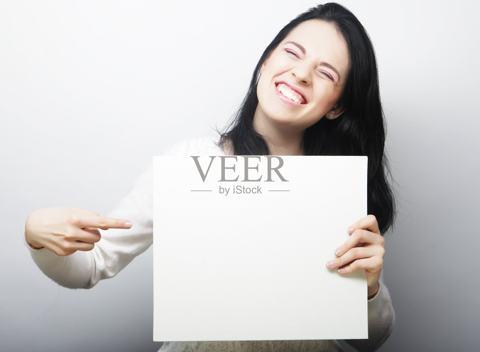 微笑的年轻休闲风格的女人显示空白的招牌照片摄影图片