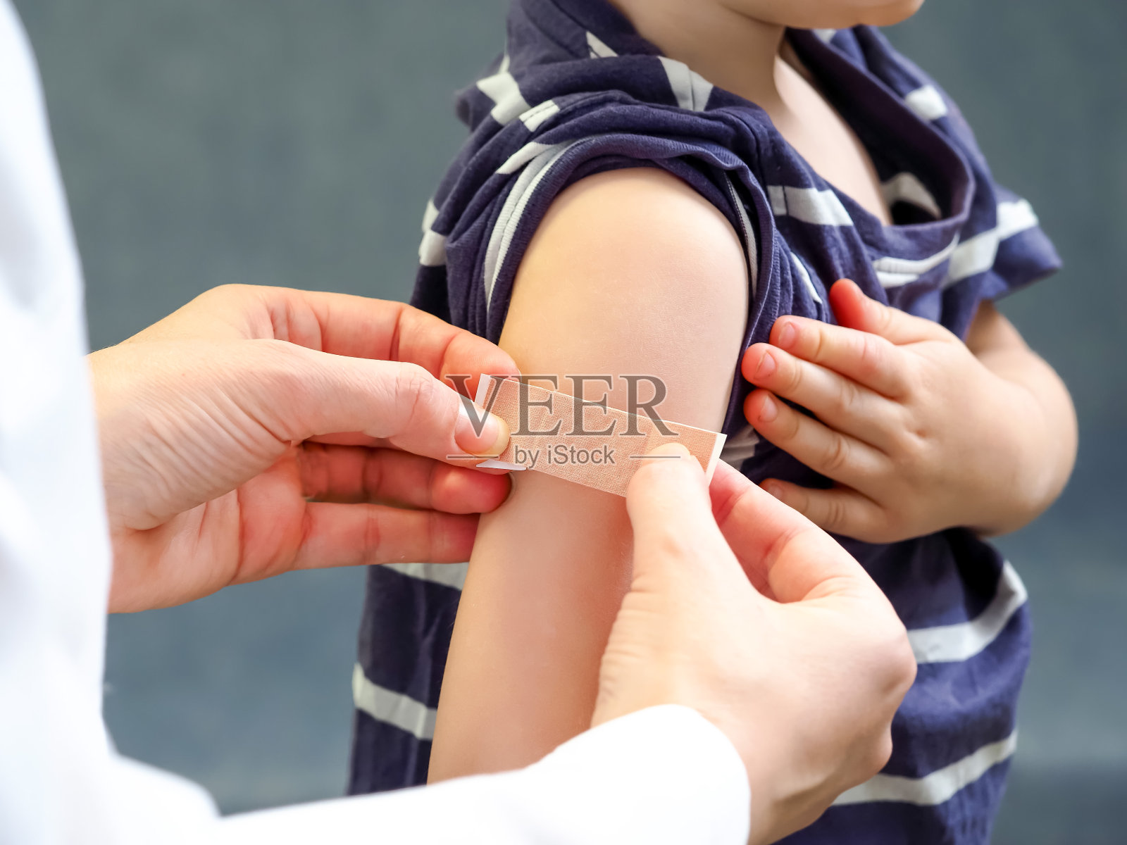 医生在孩子的伤口上贴了膏药照片摄影图片