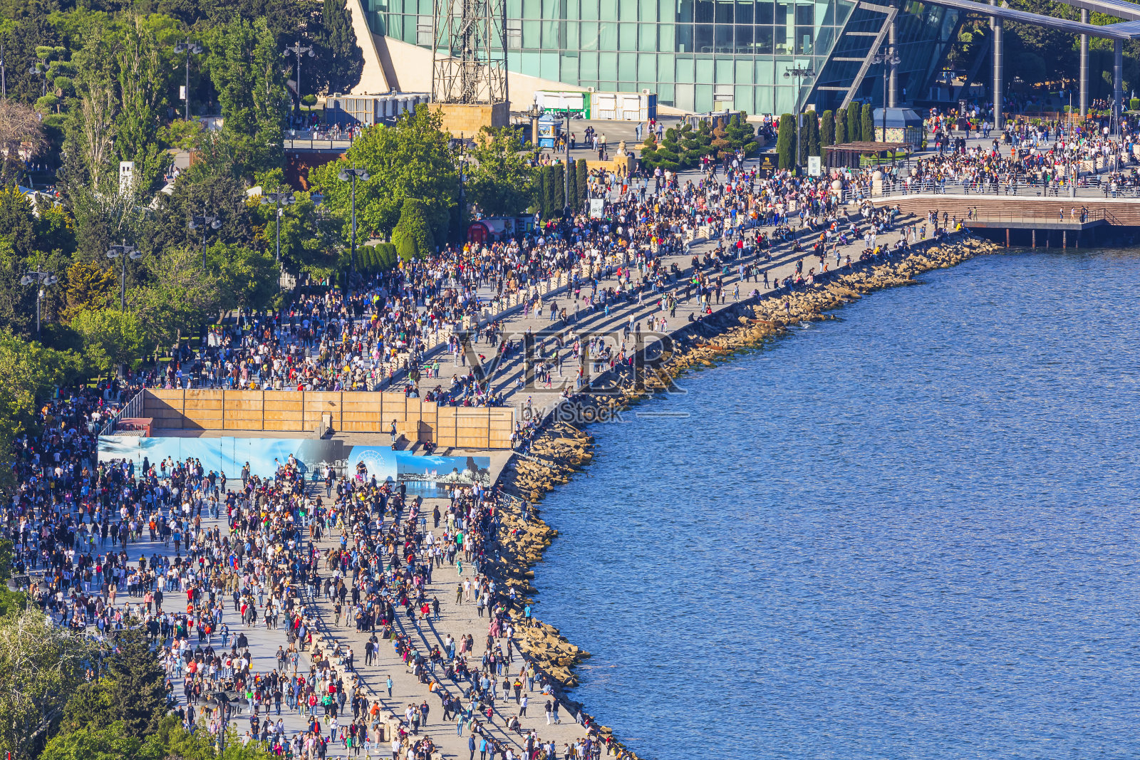 在巴库海边的林荫大道上走着许多人照片摄影图片