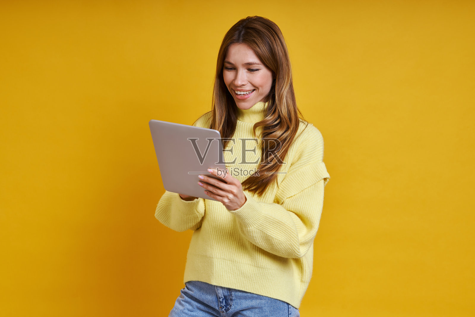 快乐的年轻女性在数字平板电脑上工作照片摄影图片