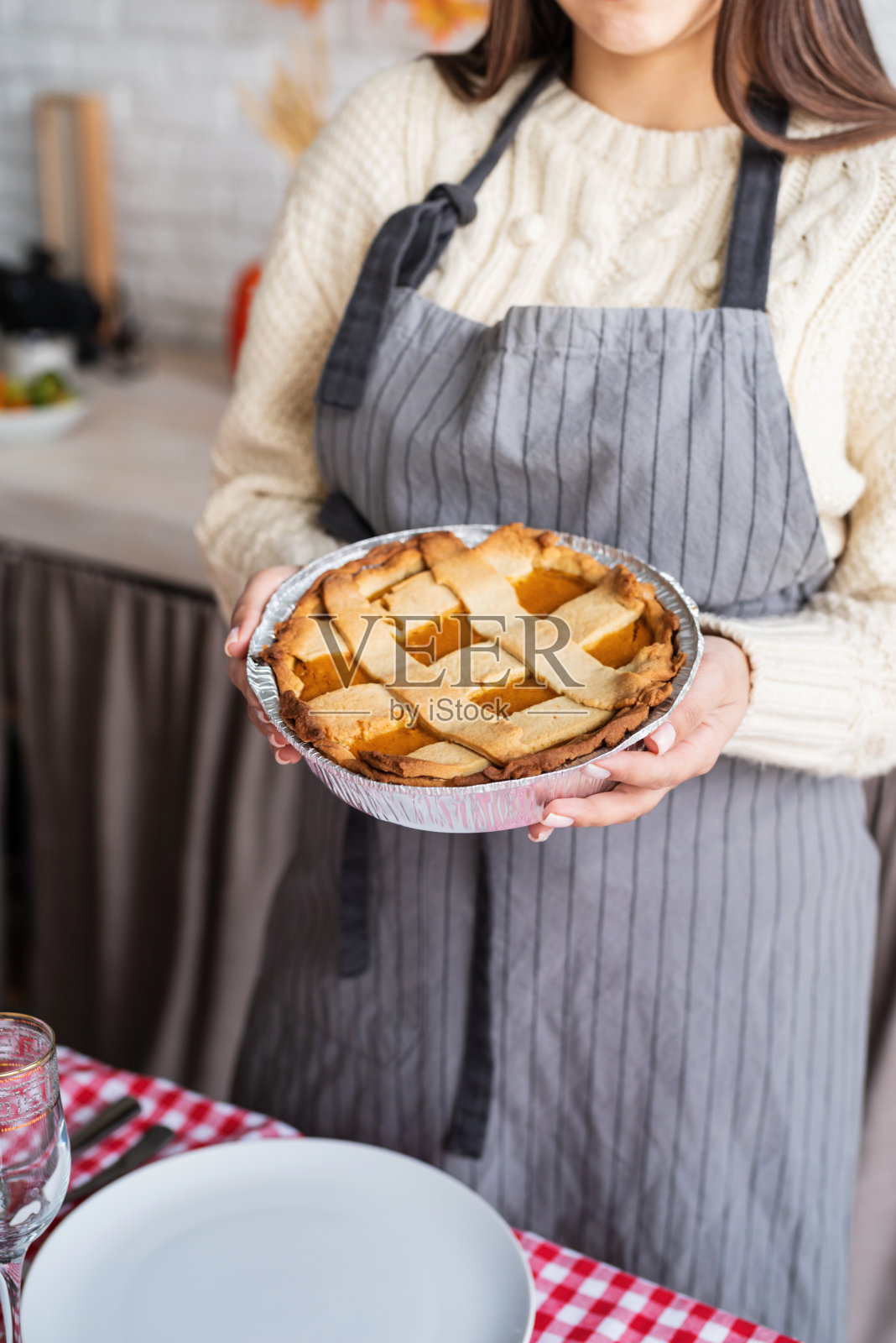 一名妇女正在家庭厨房为感恩节晚餐准备南瓜派照片摄影图片