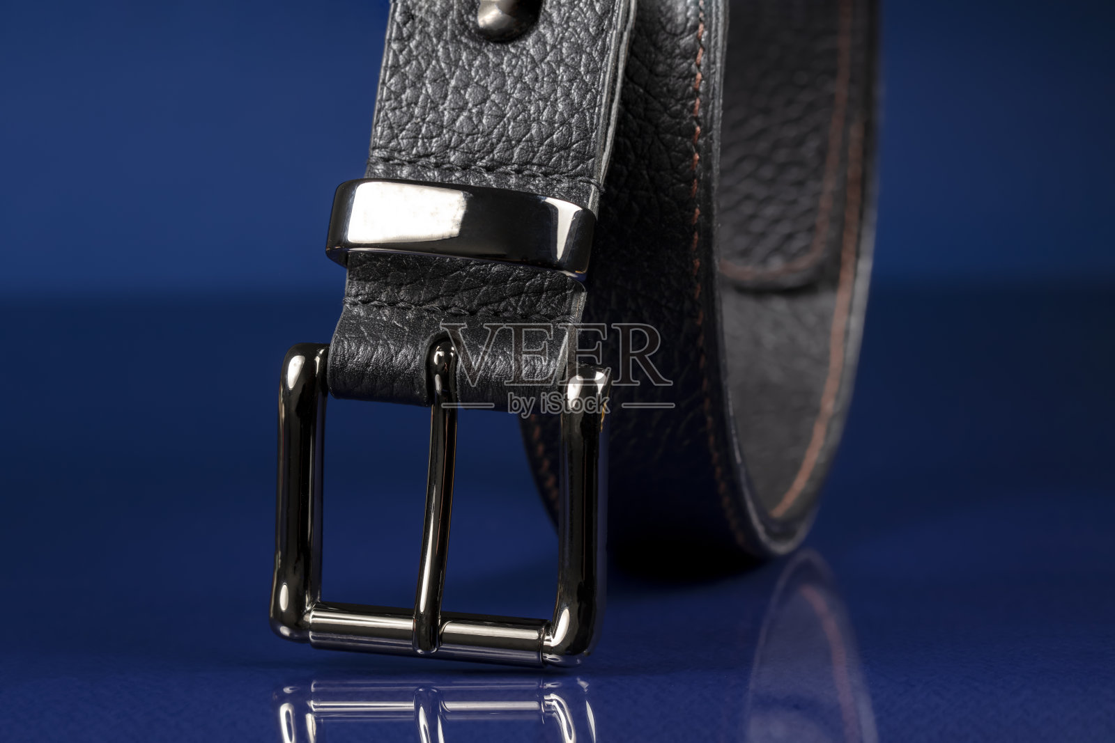 黑色皮带在深蓝色的背景。照片摄影图片