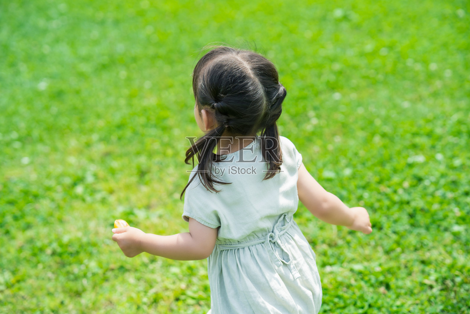 女孩在草坪上玩耍照片摄影图片