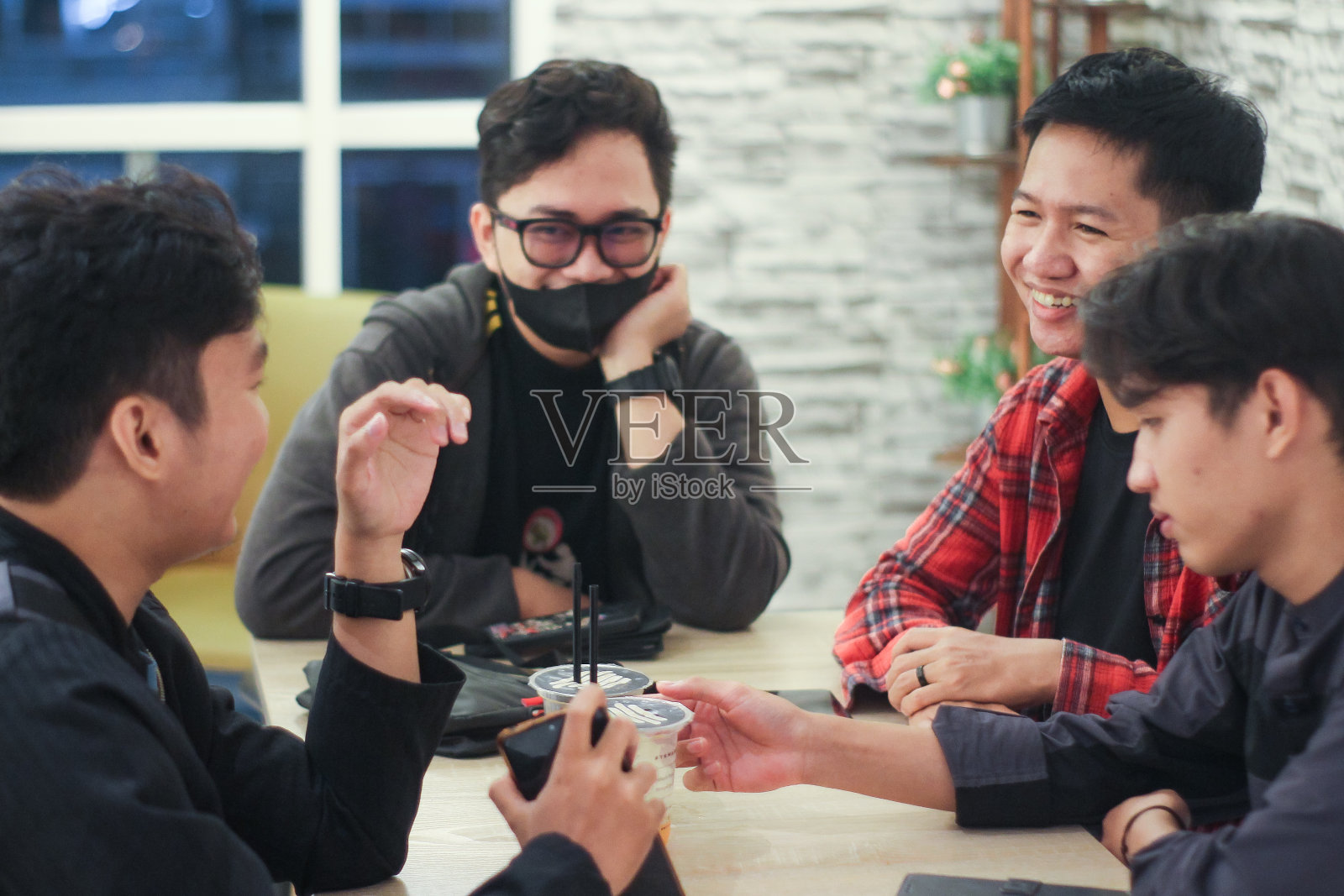 一群年轻人在咖啡馆里打电话聊天照片摄影图片