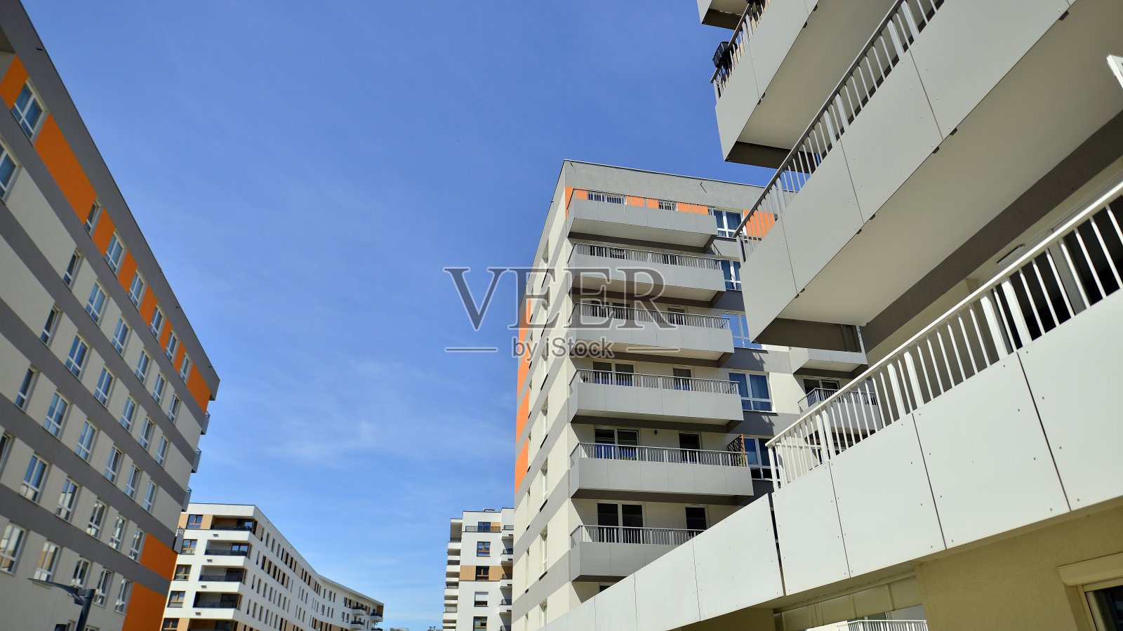 蓝天下的公寓楼。一座现代化公寓楼的立面。照片摄影图片