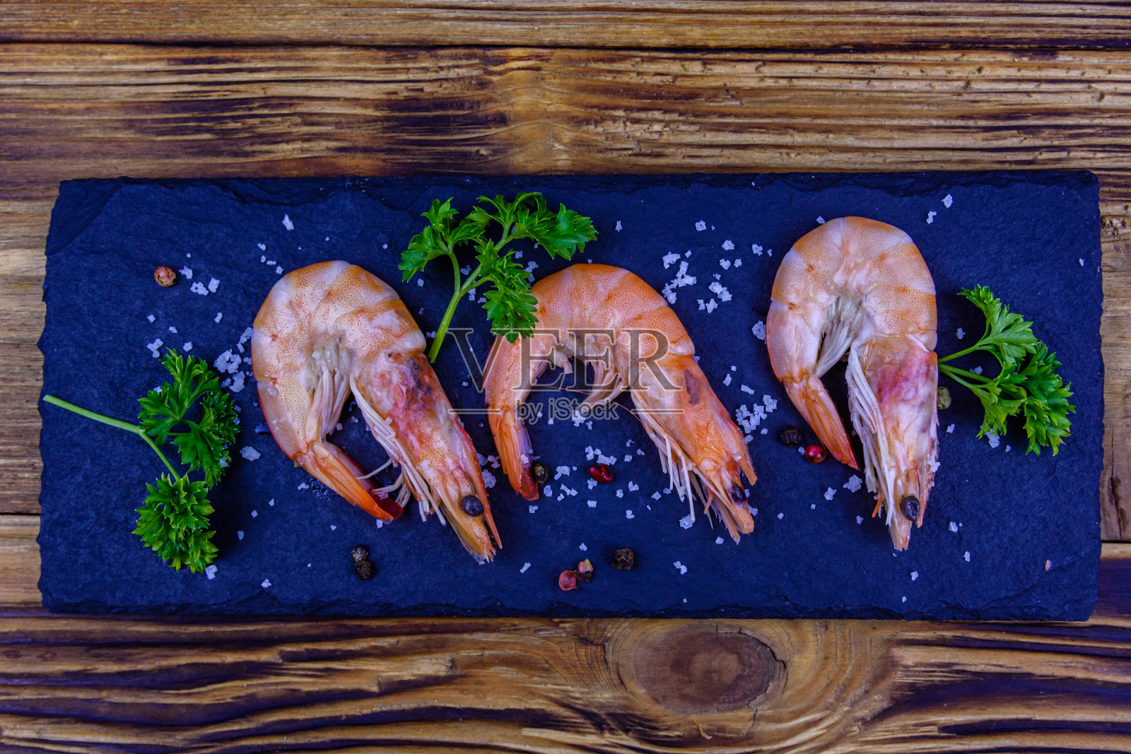 虾仁加香料，盐和欧芹放在石板上。俯视图照片摄影图片