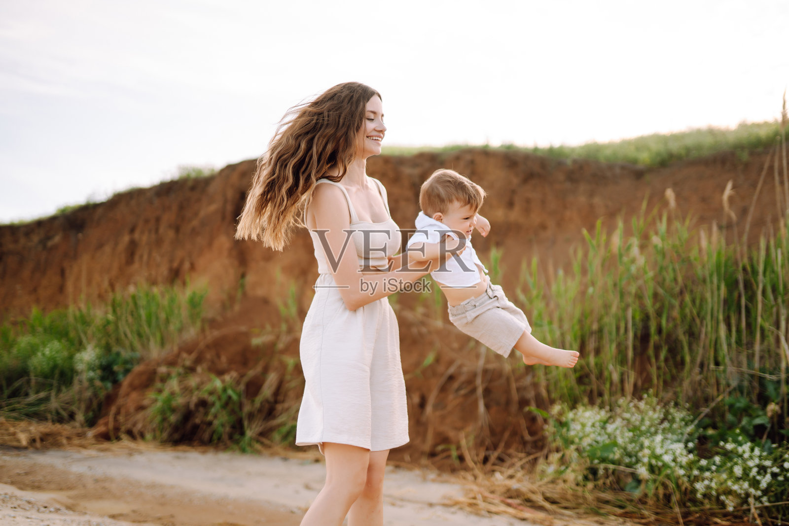 美丽的母亲和孩子在海滩上休息。照片摄影图片