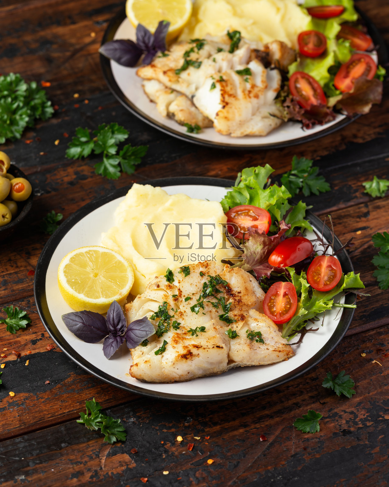 炸鳕鱼里脊配土豆泥，蔬菜沙拉配新鲜柠檬照片摄影图片