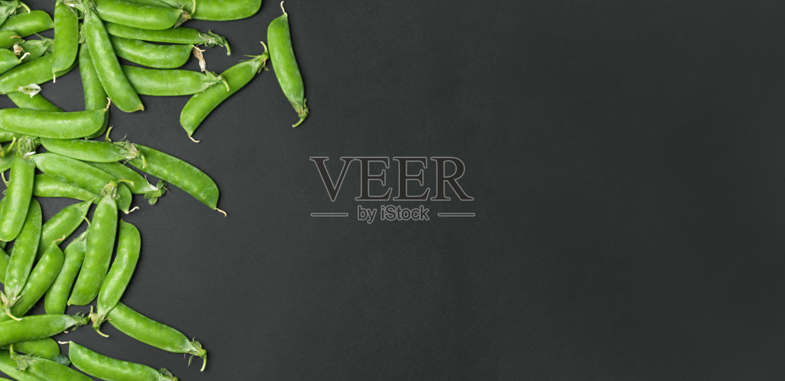 新鲜的青豆与荚在碗在黑色的背景照片摄影图片