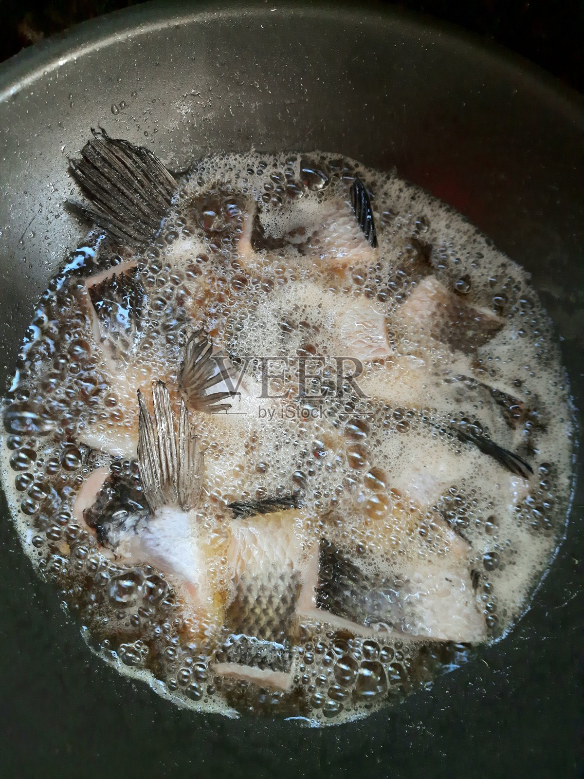 煎蛇头鱼-煎锅食品的准备。照片摄影图片