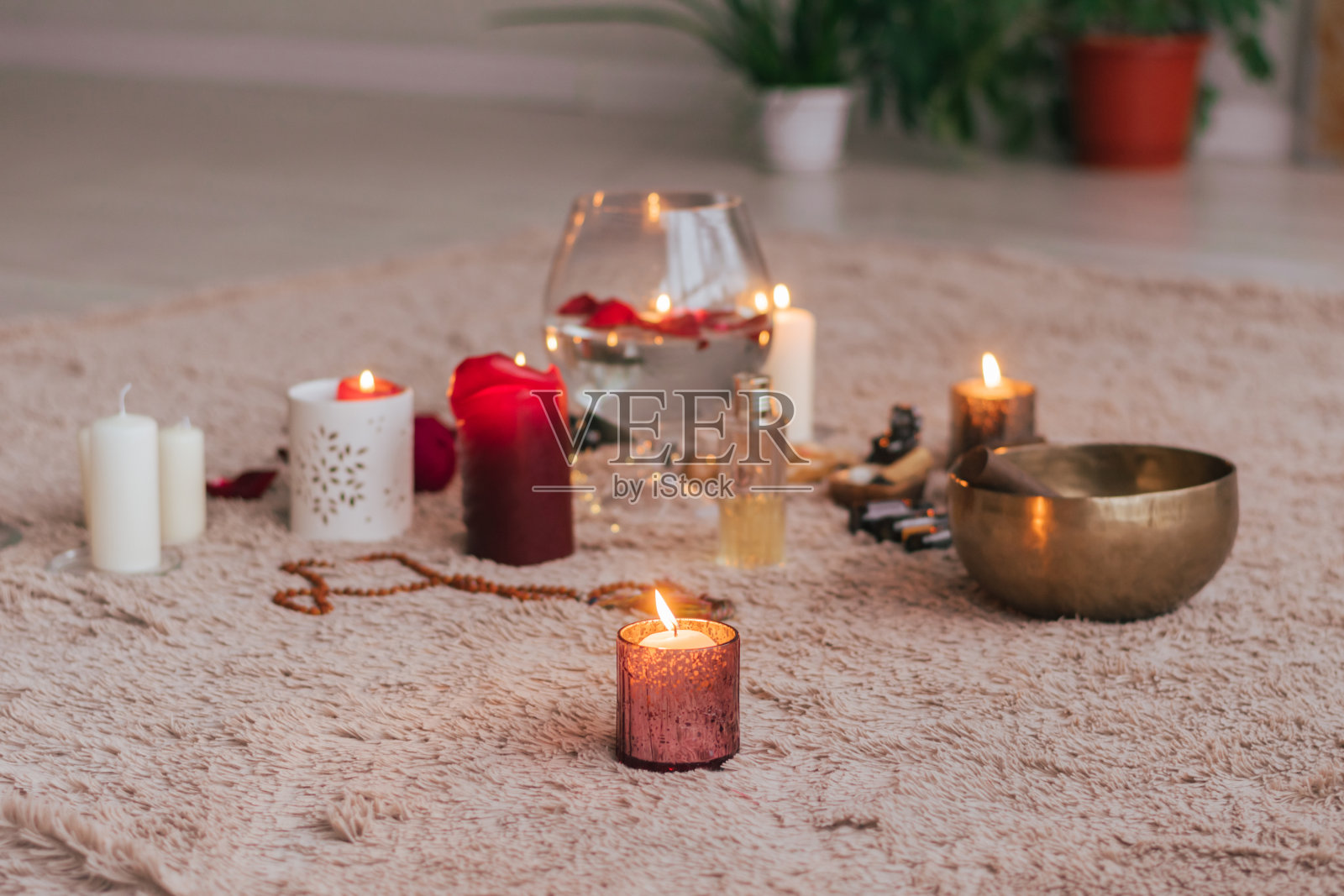 放松冥想的气氛点燃蜡烛，红玫瑰花瓣必不可少地躺在柔软蓬松的地毯上照片摄影图片