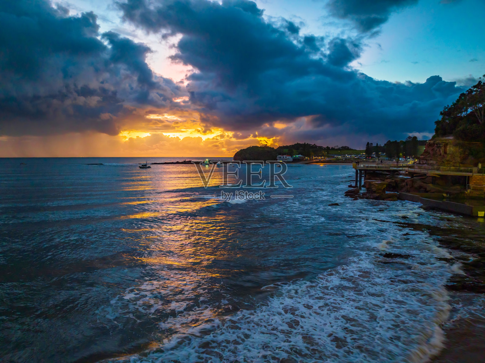 海边的空中日出，有雨云照片摄影图片