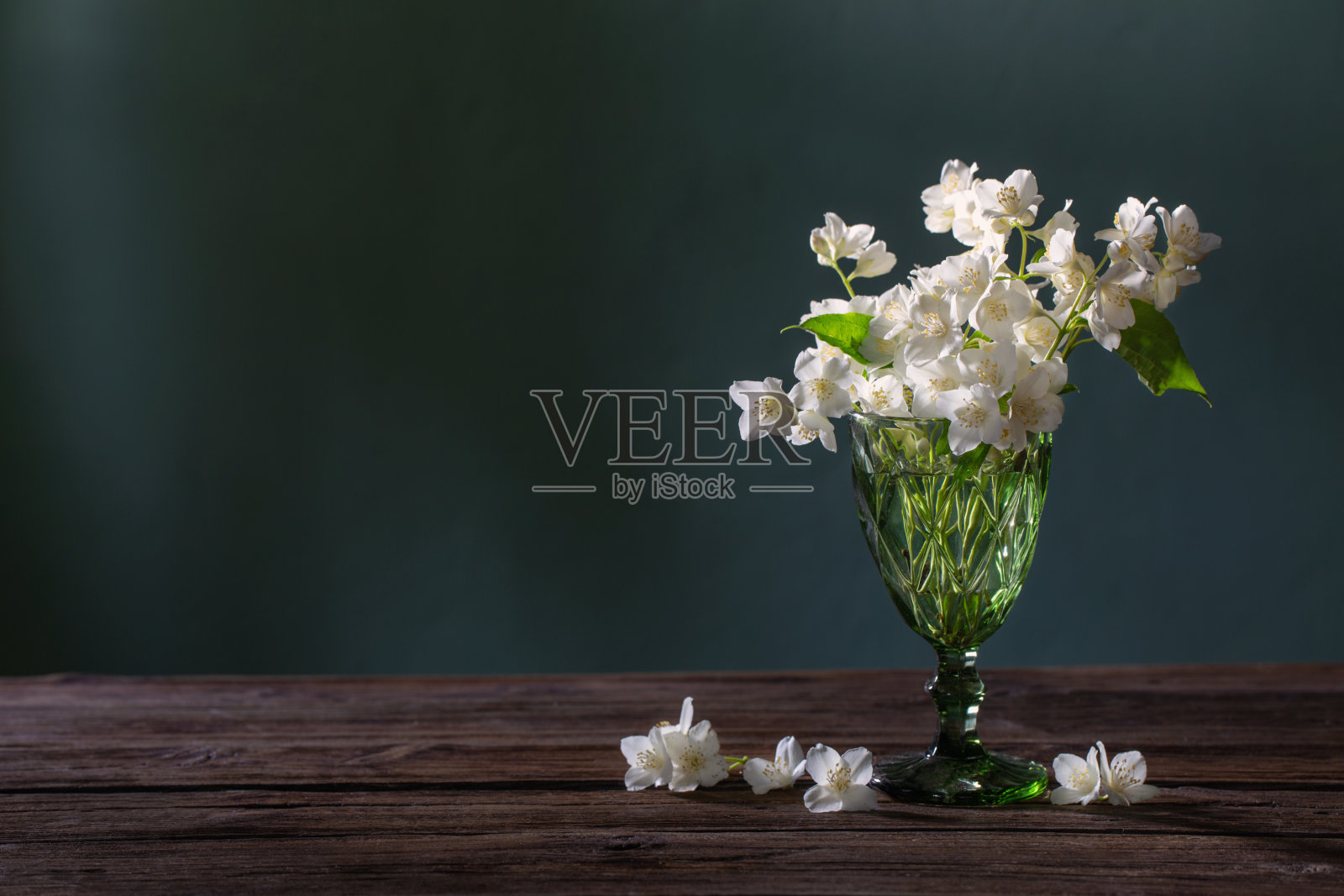 茉莉花在绿色背景的玻璃花瓶照片摄影图片