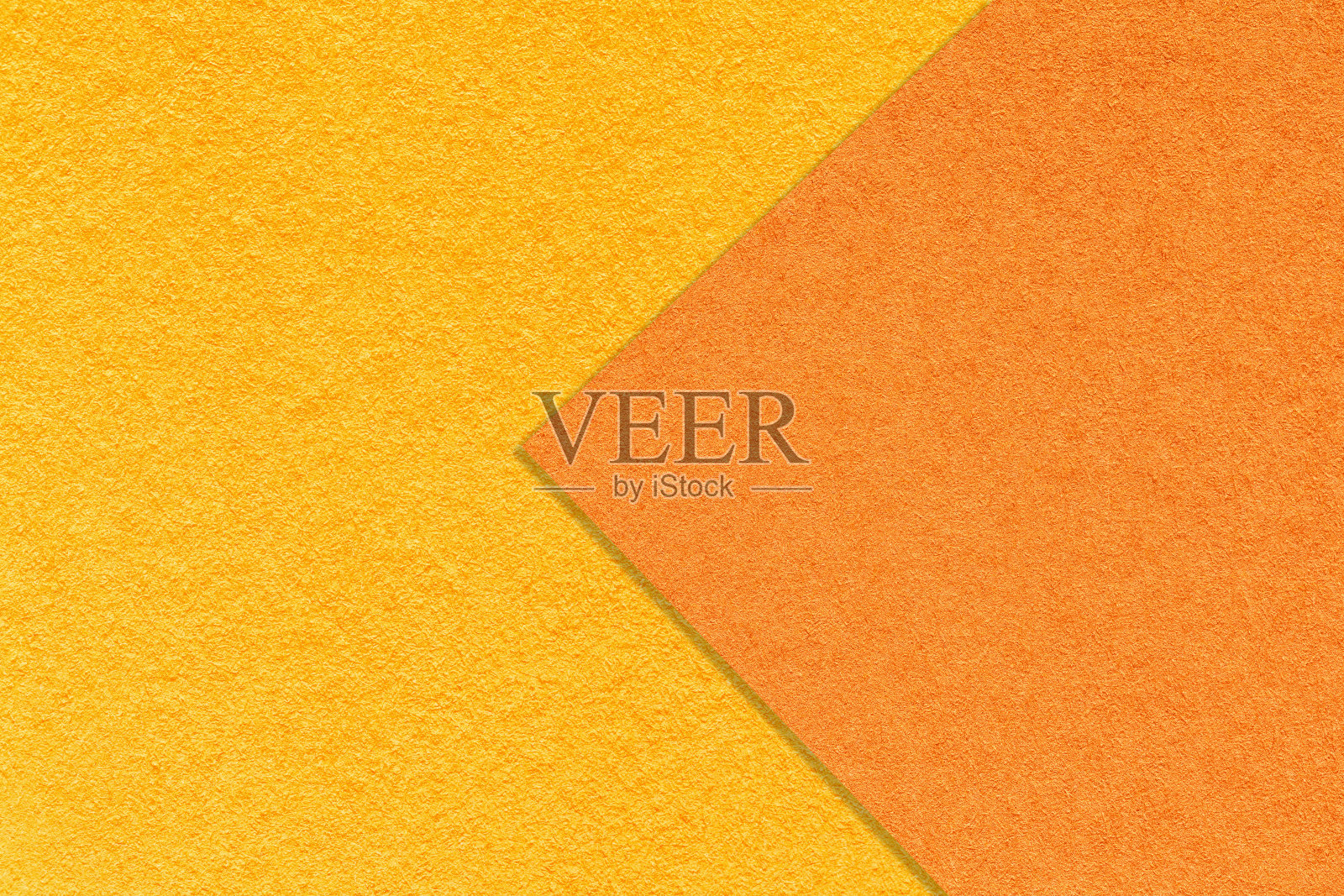 纹理明黄色和橙色的纸张背景，一半两种颜色与箭头，宏观。金纸板结构。照片摄影图片