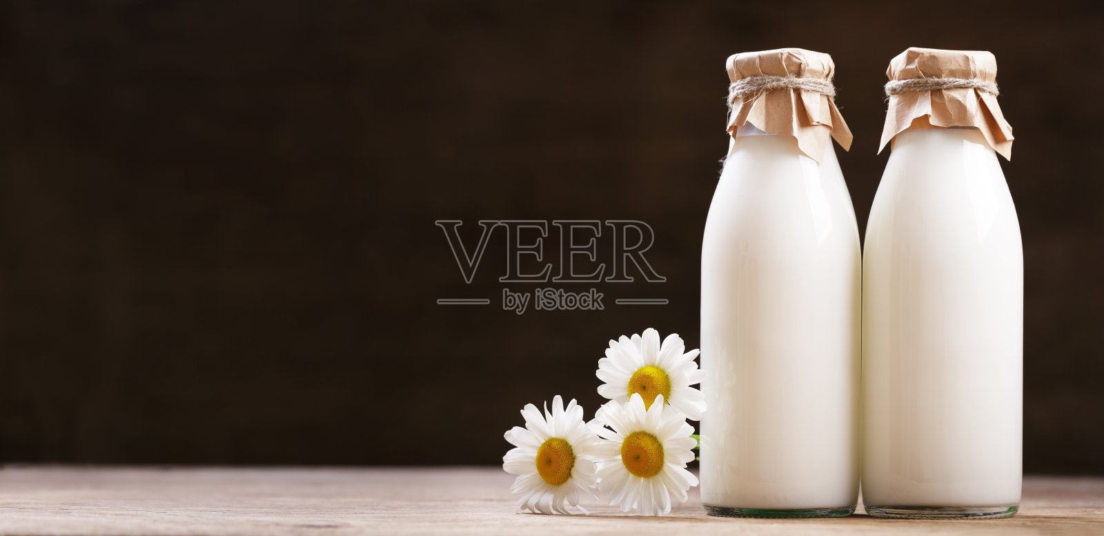 几瓶新鲜牛奶和雏菊花照片摄影图片