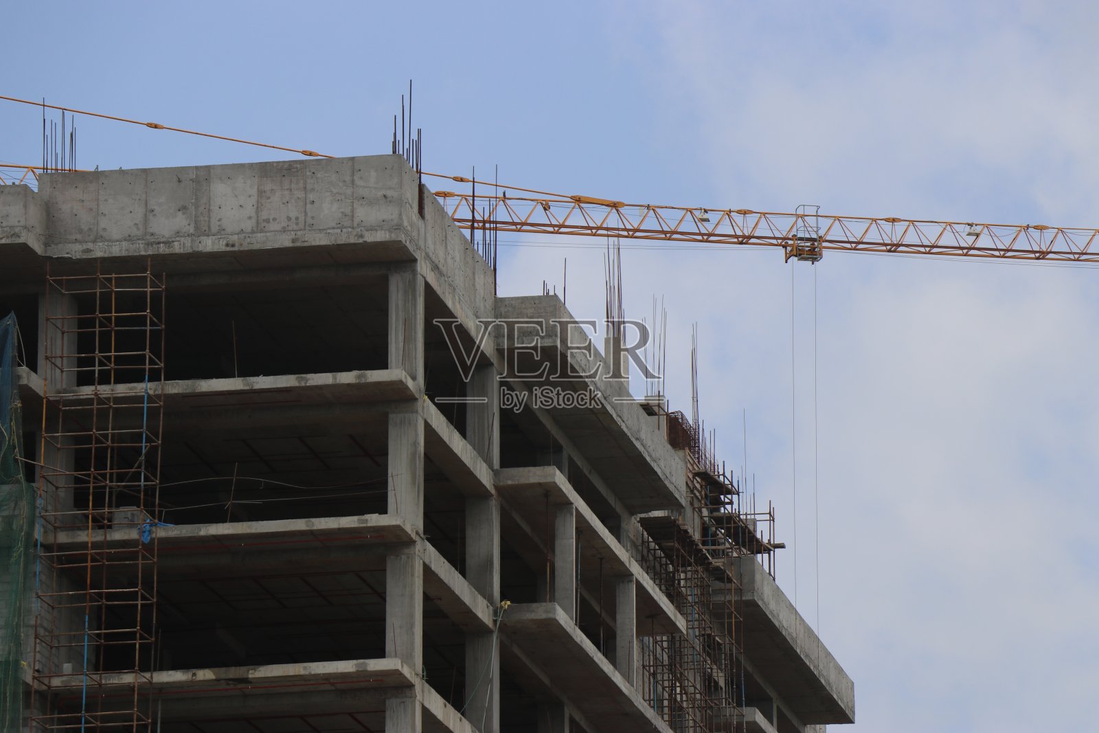 在工地上用起重机建造新建筑。吊车与建筑工地映衬着苍穹照片摄影图片