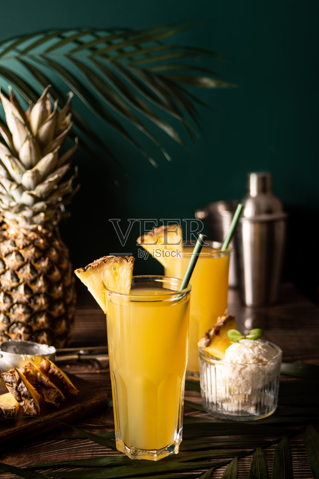 夏天清爽的热带饮料果汁或鸡尾酒菠萝汁和龙舌兰与纸吸管和冰淇淋的背景。照片摄影图片