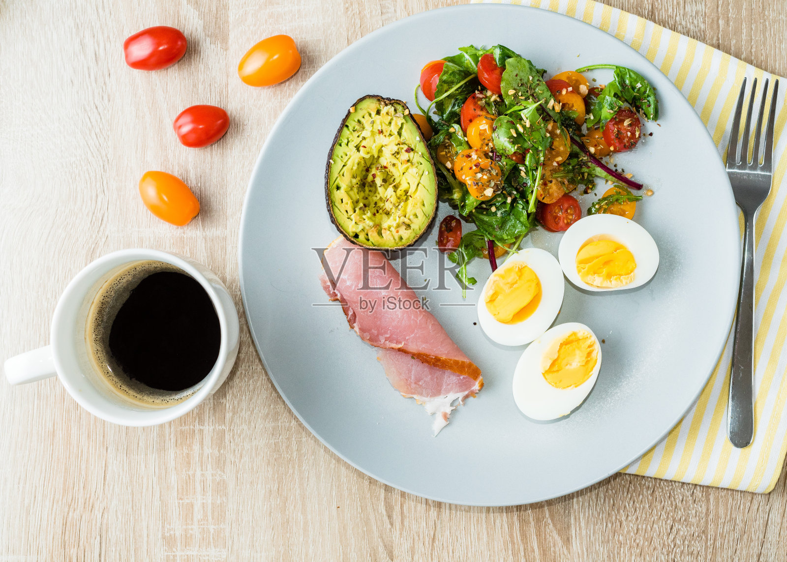 盘子里放着生酮类减肥食品。鸡蛋，蔬菜沙拉，西红柿，培根，鳄梨和一杯咖啡。酮的早餐。长长的横幅格式照片摄影图片