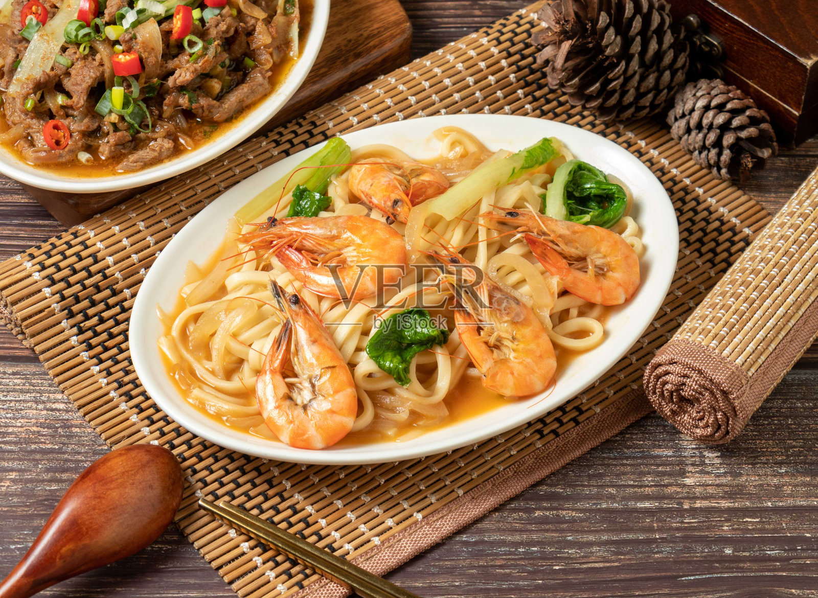 虾仁炒面在菜垫上孤立，侧观深色木桌上的台湾菜照片摄影图片