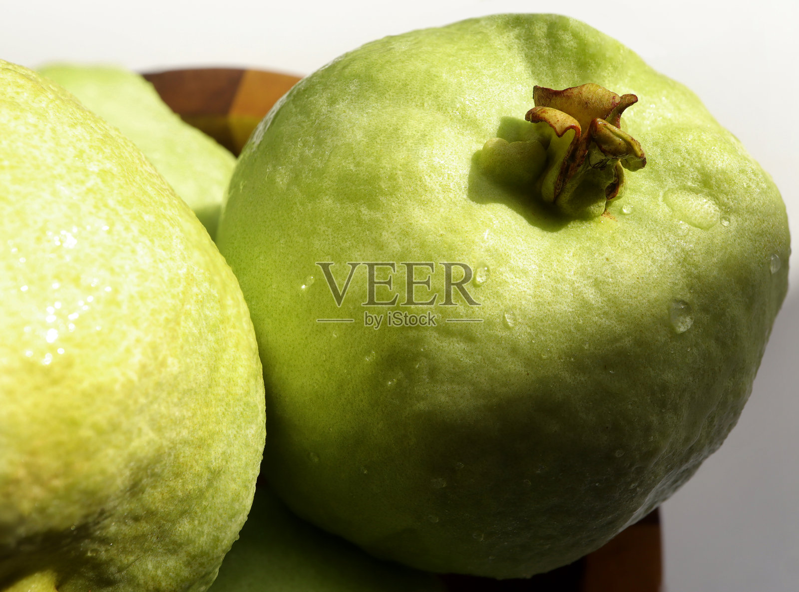 靠近新鲜的番石榴水果与硬阴影在一个木碗。有选择性的重点。照片摄影图片