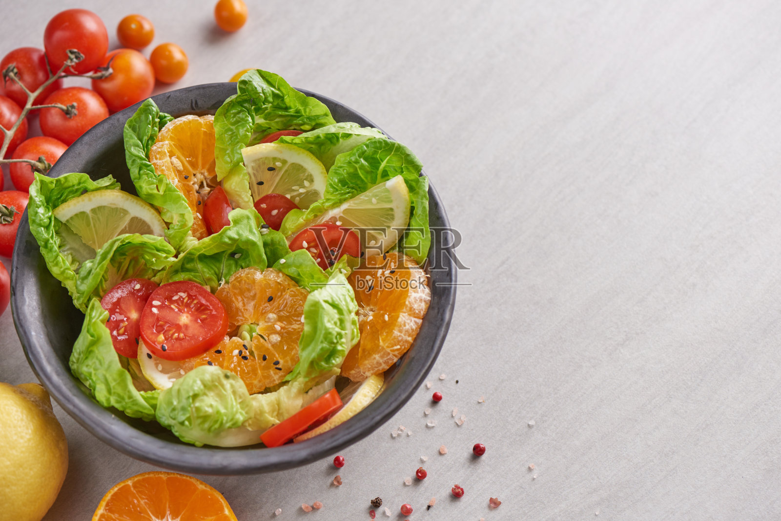 饮食菜单。健康新鲜蔬菜水果沙拉，素食午餐碗，佛碗沙拉配食材。Mini cos，番茄，橙子，柠檬，芝麻。健康均衡的素食理念。照片摄影图片