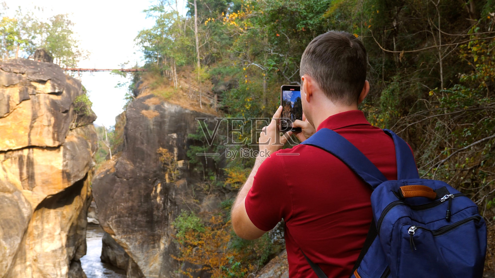 休闲旅游博主在泰国国家公园拍摄令人惊叹的自然视频。30多岁的森林徒步旅行者摄影师背着背包为社交媒体拍摄了峡谷的视频。照片摄影图片